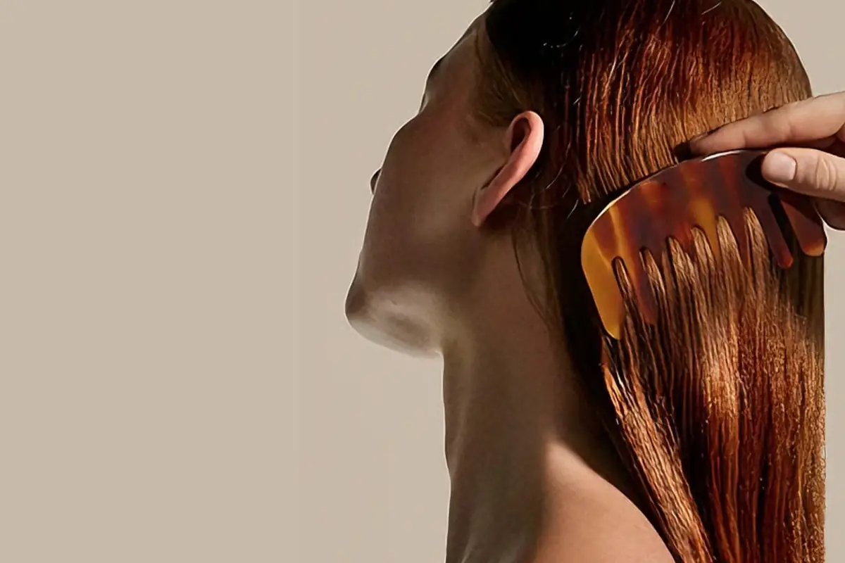 Hair oil application with comb on wet hair showing shine softness and salon-style hair care treatment