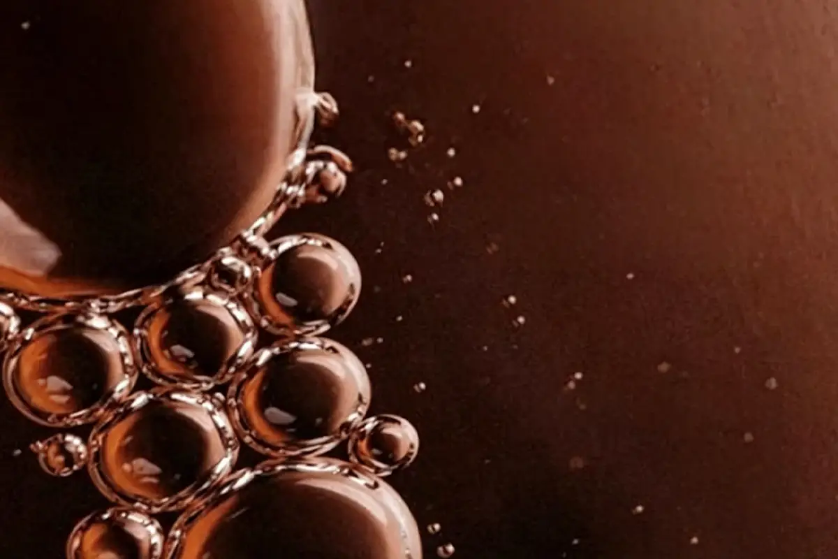 Amber hair oil texture macro showing oil droplets for private label hair growth oil formulation and stability testing