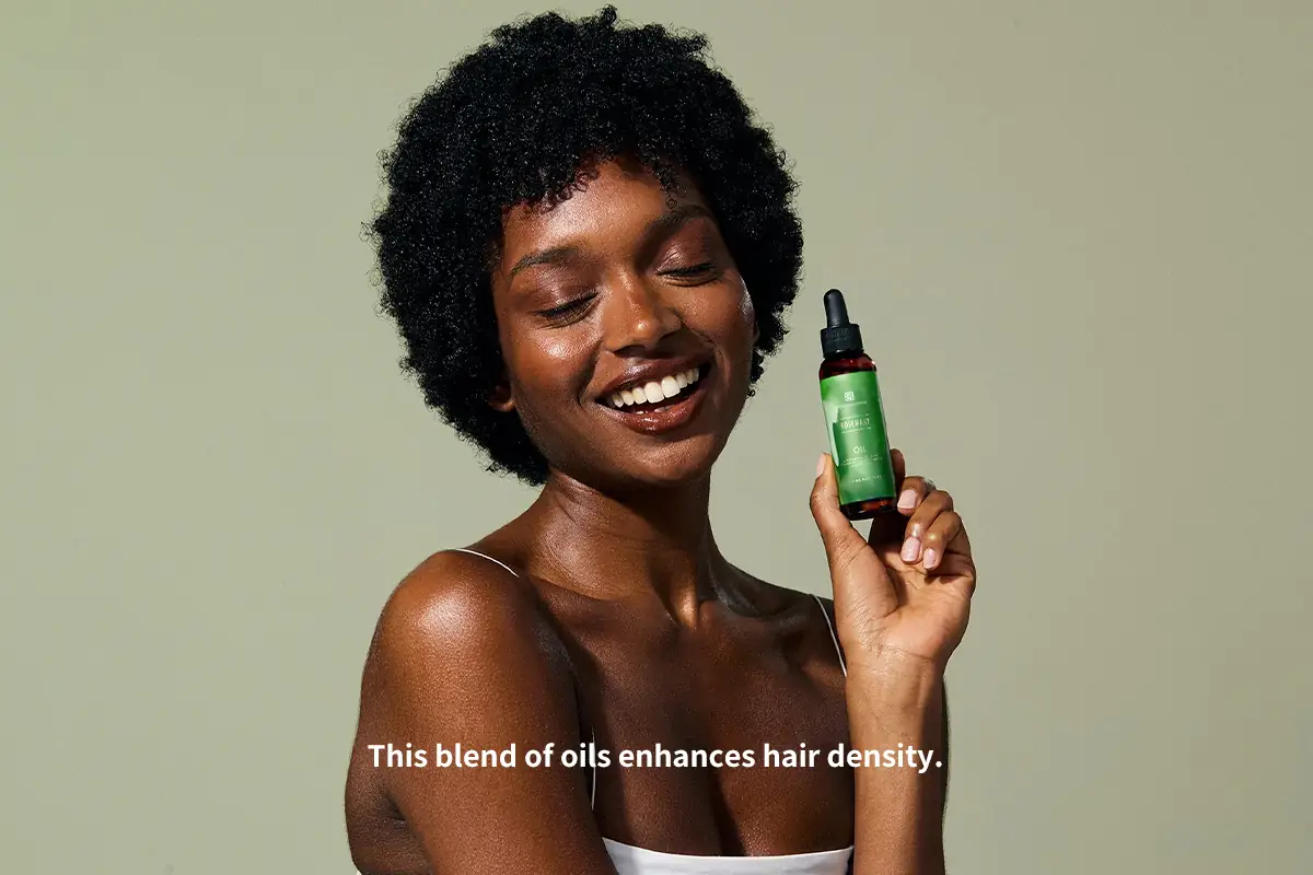 Model holding rosemary hair growth oil for private label scalp and hair density support products