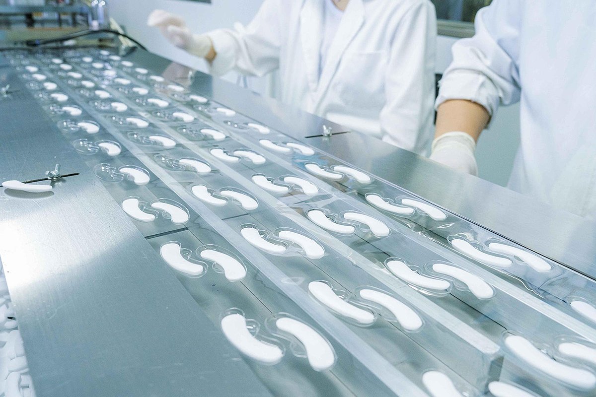 Workers inspect freeze-dried eye mask patches on a controlled production line at Shangpinhui Biotechnology.